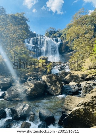 Gorgeous waterfall surrounded by verdant tropical vegetation in Sri Lanka.
