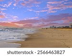 a gorgeous winter landscape at sunrise with beachfront condos, people walking, tall brown grass in Carolina Beach North Carolina USA