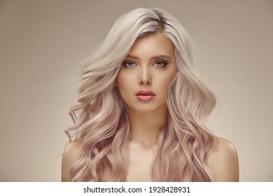 Gorgeous Woman With Beautiful Wavy Pink Hair On A Beige Background