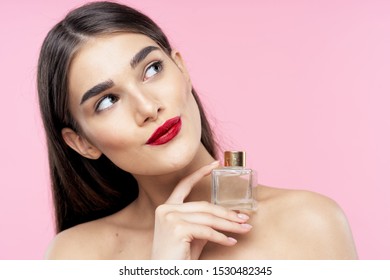 Gorgeous woman with bright makeup on model and perfume bottle in hand