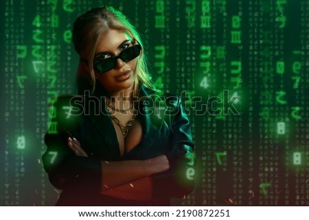 Gorgeous woman in matrix style suit. Black leather and reflection of code in glasses in green light and shadows of the matrix. Cyber technology concept, future and progress