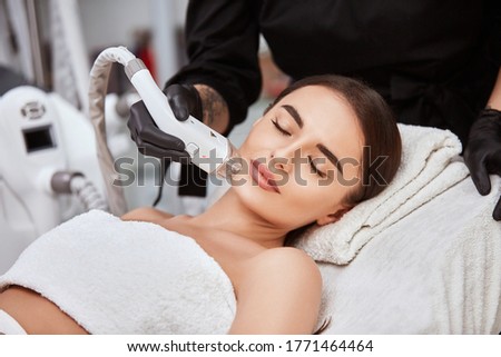 gorgeous woman with perfect skin and eyebrown receiving hair removal on her face, pretty girl in spa doing procedures for her lovely face