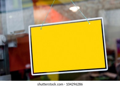 gorgeous yellow sign hanging on a window door outside a restaurant, store, office or other (copy-space available for design)