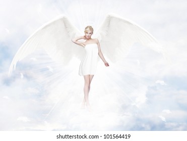 Gorgeous young blond woman as angel in heaven with white wings