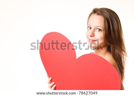 Gorgeous young brunette fooling around with large red heart shape, isolated on white background.