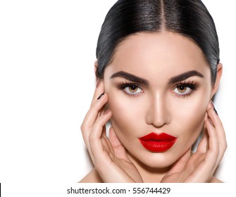 Gorgeous Young Brunette Woman face portrait. Beauty Model Girl with bright eyebrows, perfect make-up, red lips, touching her face. Sexy lady makeup for party. Isolated on white background