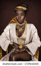 A gorgeous young female Egyptian Pharaoh wearing elegant clothing, a gold crown and jewelry is sitting on her golden throne.
