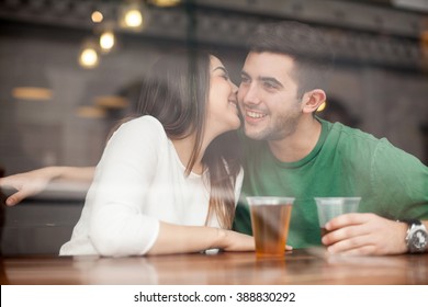 Gorgeous Young Flirty Girl Drinking Beer With A Guy In A Bar And Whispering In His Ear