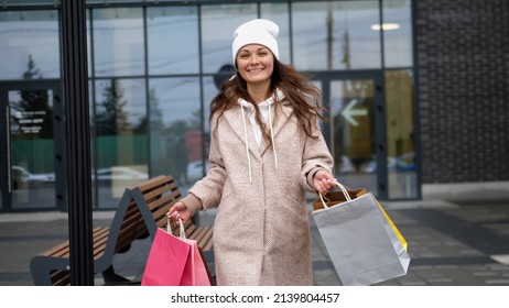 Gorgeous young happy woman with different bags walking in a city