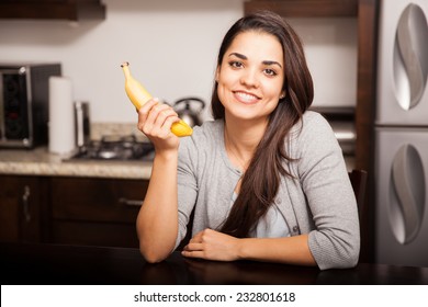 Gorgeous Young Woman About To Eat A Banana At Home And Smiling