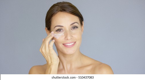 Gorgeous Young Woman Applying Face Cream