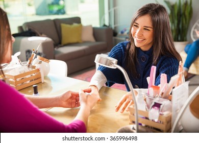 Gorgeous Young Woman Getting Her Nails Done By A Manicurist In A Beauty Salon