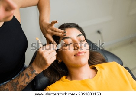 Gorgeous young woman having a brow wax depilation in the beauty room and new eyebrow design