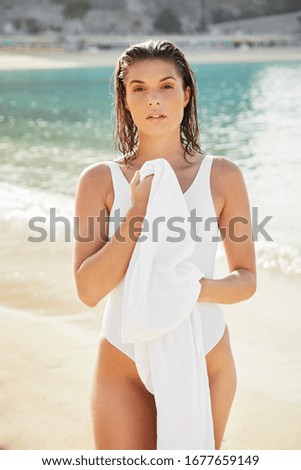 Gorgeous Young Woman On Beach Holding Towel, Portrait