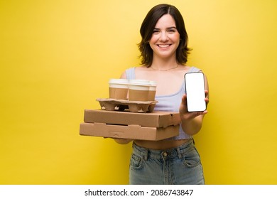 Gorgeous Young Woman Ordering Takeout Food Through A Delivery App And Holding Her Smartphone