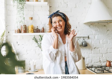 Gorgeous Young Woman Plus Size Body Positive In Blue Jeans And White Shirt Talking On Cellphone At Home Kitchen