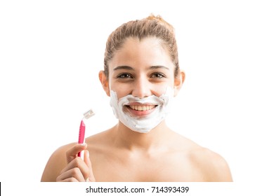 Gorgeous Young Woman Shaving Her Facial Hair With Some Cream And A Razor On A White Background