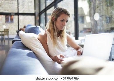 Gorgeous Young Woman Watching Movie On Laptop Computer While Waiting For A Friends In Cozy Cafe, Beautiful Hipster Girl Reading Fashion News Via Net-book During Recreation Time In Favorite Coffee Shop