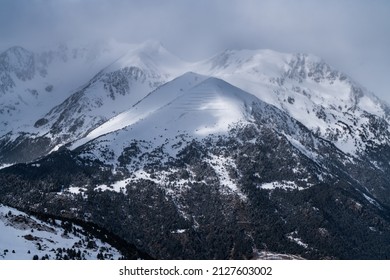 Gorgeus snowy mountain range an the Avalanche walls on the snowy peak. Located in the Pyrenees range between Spain and France. Amazing half cloudy half sunny day. View from the mountain tops. 