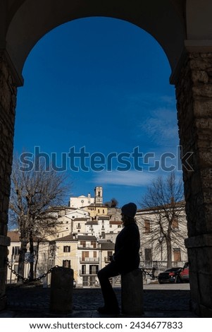 Goriano Sicoli, Italy A woman sits on a stoop in sihouette under an arch with a view over this medieval hilltop town.