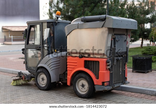 Gorki Gorod, Sochi,\
Russia. July 9, 2020 : a small orange utility car sweeps the\
streets of the city