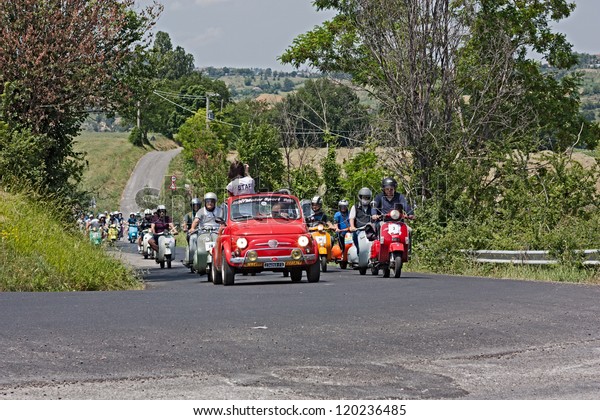 GOROLO DI BORGHI (FC) ITALY - JUNE 3: an old Fiat\
500 leads the group of scooter riders in rally of Italian scooters\
\
