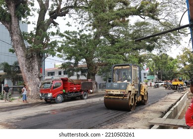 Gorontalo, October 5, 2022 : Asphalt Paver Machine And Truck. Road Construction Crew Apply The First Layer Of Asphalt. Hot Mix Asphalt Paving And Road Work - Flatten Out The Hot Asphalt Road With Road