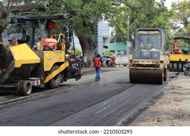 Gorontalo, October 5, 2022 : Asphalt Paver Machine And Truck. Road Construction Crew Apply The First Layer Of Asphalt. Hot Mix Asphalt Paving And Road Work - Flatten Out The Hot Asphalt Road With Road