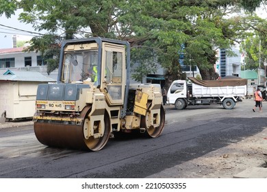 Gorontalo, October 5, 2022 : Asphalt Paver Machine And Truck. Road Construction Crew Apply The First Layer Of Asphalt. Hot Mix Asphalt Paving And Road Work - Flatten Out The Hot Asphalt Road With Road