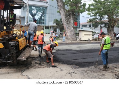 Gorontalo, October 5, 2022 : Asphalt Paver Machine And Truck. Road Construction Crew Apply The First Layer Of Asphalt. Hot Mix Asphalt Paving And Road Work - Flatten Out The Hot Asphalt Road With Road