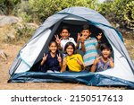 gorup of kids inside camping tent grimacing by looking at camera during summer camp of hill top - concpet of happiness, relaxing and vacation