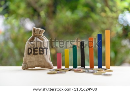 Gorvernment or public  national debt concept : Color wood bar graph, coin and a debt bag on a table, depicts the government collects taxes less than spending, the difference is called deficit or debt Сток-фото © 