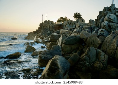 Goseong County, South Korea - November 3, 2024: Waves crash against the rugged rocks of Neungpadae as the early morning light illuminates this striking coastal landscape along the East Sea. - Powered by Shutterstock