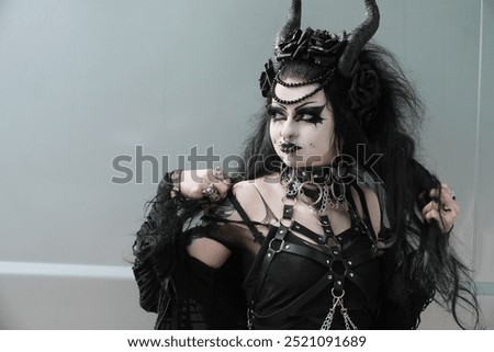 Similar – Image, Stock Photo Portrait of a gothic rocker-looking woman, looking directly at the camera, wearing a leather jacket, on plain gray background