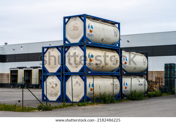 Gothenburg, Sweden - July 24\
2022: Stack of universal tank containers on a storage lot by a\
warehouse.