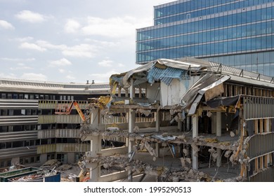 Gothenburg, Sweden - June 20 2021: Half demolished office building. Containers with rubbish on the ground. Glass facade in the background. No visible people