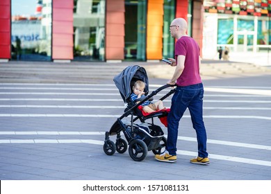 Gothenburg, Sweden - May 16, 2019: Man Pushing Push Chair Of His Boy Around Lindholmen It Is Common View In Sweden Father Travel With Push Chair