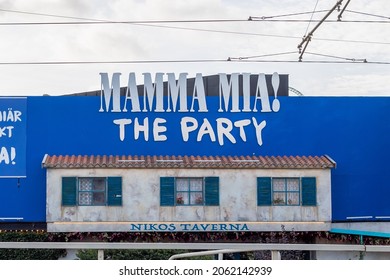 Gothenburg, Sweden - Oct 16 2021: Sign for Abba Mamma Mia show on a wall with a prop of a greek house with windows.  No visible people.