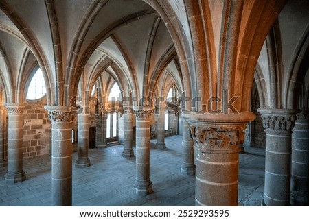 Gothic arches and stone columns inside Mont Saint Michel Abbey create a serene, timeless atmosphere. This historic French landmark showcases medieval architecture and spiritual elegance.
