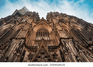 Gothic cathedral facade, showcasing intricate details against a clear blue sky. The upward perspective highlights the majestic architecture and historical significance of this historical landmark - Powered by Shutterstock