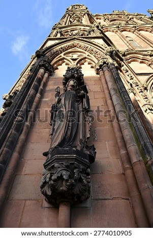 Gothic cathedral statue of Wisdom beneath ornate carved sandstone arch