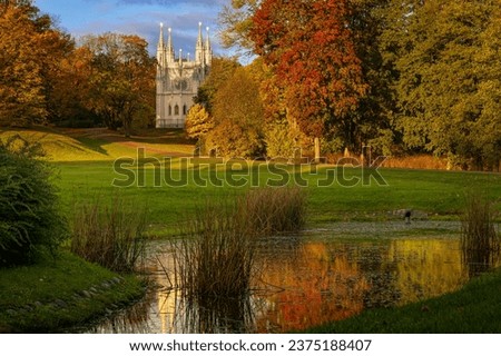 Gothic chapel in Alexandria Park in Peterhof, St. Petersburg in autumn morning next to a small pond