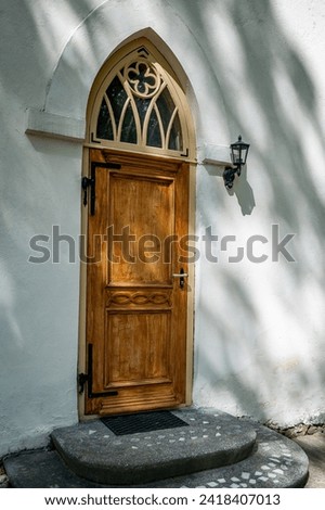Gothic church entrance close up. Closed wooden door. Smiltene Lutheran Church in sunny summer day, Latvia. 
