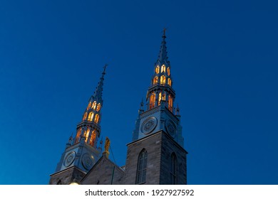 Gothic church spires lit up at night with a clear blue sky background - Powered by Shutterstock