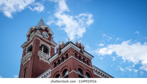 A gothic clocktower, set against a blue sky.