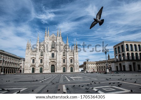 The gothic Duomo Cathedral facade in Milan, Italy on a beautiful spring day. Empty Duomo square. Blue sky with scattered soft clouds. Lockdown, curfew 