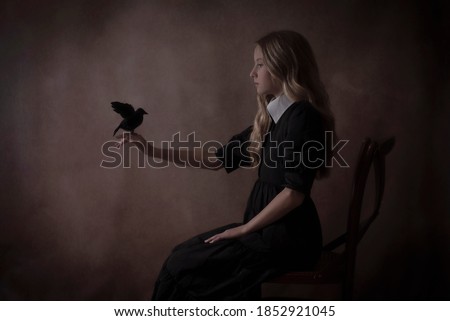 Gothic girl holding a crow.