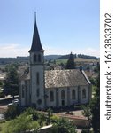 Gothic style catholic church with slopped tile roof and large bell tower in the Swiss town of Murten, Fribourg, Switzerland, Summer 2018