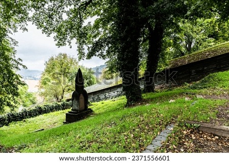 Gothic tombstone with the covered staircase in the background. Sighisoara, Romania.