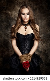 Gothic Woman Black Dress, Flower Rose in Hands Tied By Rope, Fashion Model Beauty Portrait